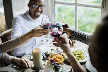 Friends toasting with red wine at restaurant table