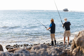 Senior man fishing with his grandson