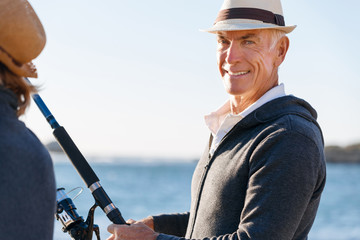 Obraz premium Senior man fishing with his grandson