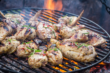Spicy chicken on grill with spices and rosemary for grill