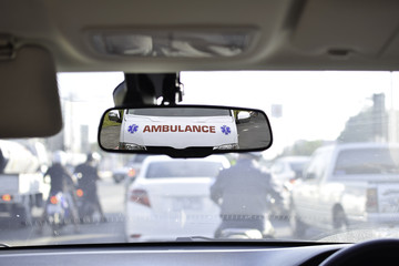 Ambulance in the rear mirror of car