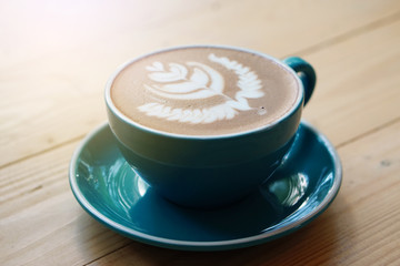 Hot Mocha - Closeup of a cup of coffee with milk and latte art on wooden table background, Morning Breakfast.