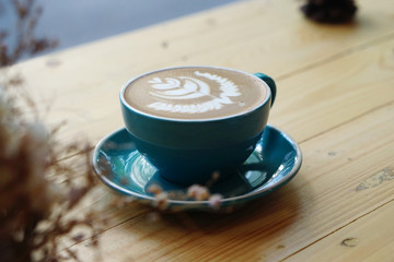 Hot Mocha - Closeup of a cup of coffee with milk and latte art on wooden table background, Morning Breakfast.
