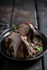Two roasted pigeons with spices and pepper on dark background