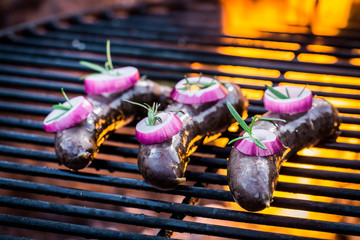 Fresh pudding with onion and rosemary on the grill