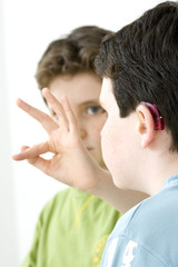 Fototapeta premium Models Do not use for HIV A young boy and his brother using the French sign language to discuss with his hearing-impaired brother The French sign language uses signs to designate words but also dactylology (each letter of the alphabet is represented by a defined position of the fingers then enabling to spell a word) and the lip reading The young boy designates the letter \f\ (see image nﾰ0833202 and series of images from nﾰ0572308 to 0573508 to see the other letters of the alphabet)
