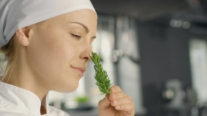 Beautiful Young Female Chef Smells Decorative Spice Plant. Shot on RED EPIC-W 8K Helium Cinema Camera.