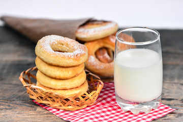 Sweet donuts with milk on wooden background