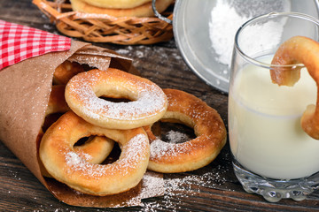 Sweet donuts with milk on wooden background
