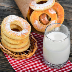 Sweet donuts with milk on wooden background