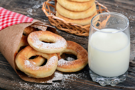 Sweet donuts with milk on wooden background
