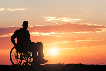 Silhouette Of A Person Sitting On Wheelchair At Sunset