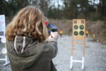 Girl shooting at outdoor gun range © Malorie