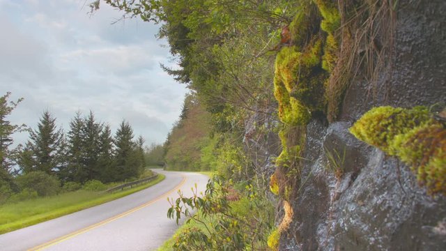 Car Driving Past Blue Ridge Mountain Rock Face With Dripping Water Sightseeing Nature On The Parkway Near Asheville North Carolina