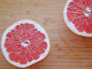 Two halves of a grapefruit on a board