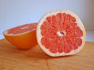 Two halves of a grapefruit on a wooden table