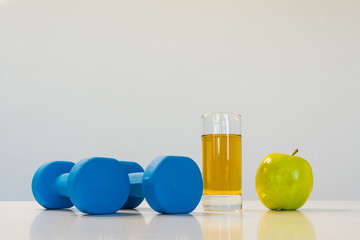 healthy eating concept. Small dumbbells. Apple juice. Green apple on a white background. healthy lifestyle. sport.