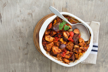 Baked chicken breast with vegetables on rustic light wooden table