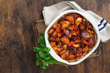 Baked chicken breast with vegetables on rustic wooden table