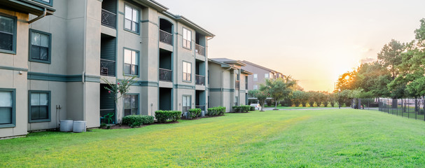 View from grassy backyard of a typical apartment complex building in suburban area at Humble,...