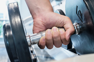 Closeup strong hand holding dumbbell