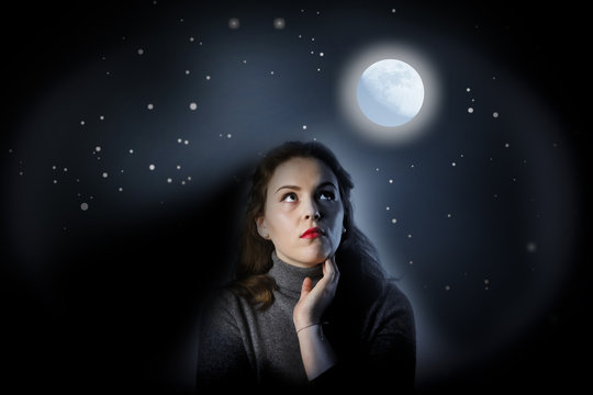 Girl in grey is looking at full moon