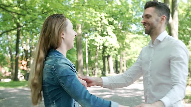 Lovely couple dancing in the park and feel happy, steadycam shot
