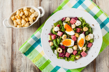 Delicious Italian salad with salami, egg, crostini and mozzarella.