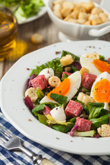 Delicious Italian salad with salami, egg, crostini and mozzarella.