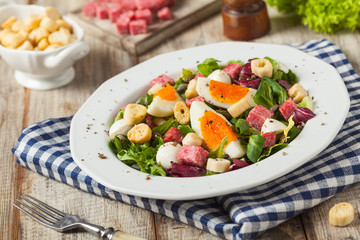 Delicious Italian salad with salami, egg, crostini and mozzarella.