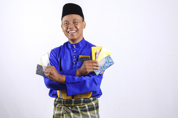 Man in traditional clothing cheerful with money packet during celebrate Eid Fitr.