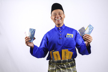 Man in traditional clothing cheerful with money packet during celebrate Eid Fitr.