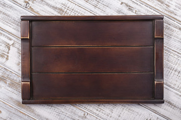 Empty dark wooden tray on gray background