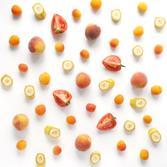 Apricots, bananas, peaches and tomatoes on a white background. Pattern of vegetables and fruits. Top view.