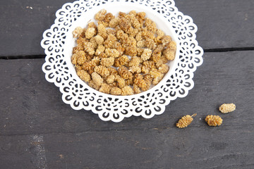 Dried mulberries on wooden background