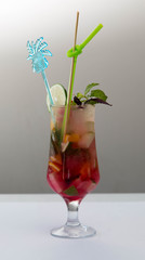 Glass of red ice tea with mint and lemon isolated