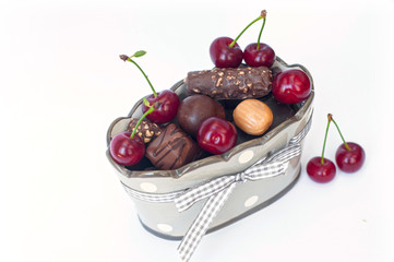 An elegant beige vase with chocolate and cherries isolated on white background