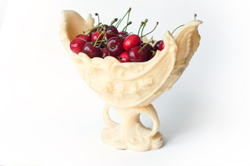 Fresh cherries in an elegant vase isolated on white background