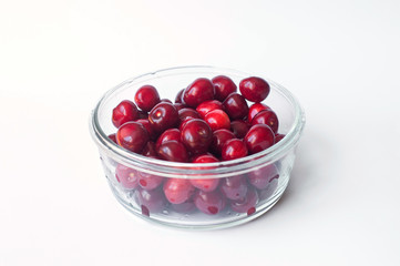 Fresh cherries in a glass bowl isolated on white background