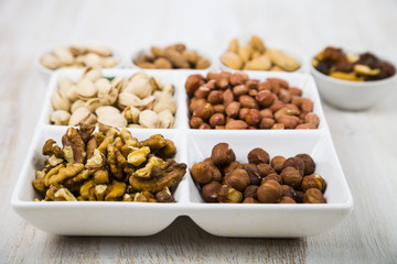 Bowls with nuts on a  wooden table