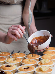 Baking cupcakes. Filling chocolate by spoon