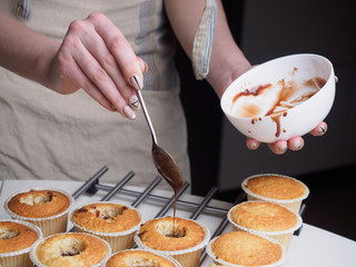 Baking cupcakes. Filling chocolate by spoon