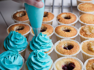 Baking cupcakes. Making cream head by pastry bag