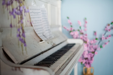 Beautiful white piano in the interior. Female hands play the piano