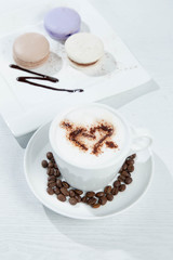 Ice coffee and coffee and nuts near desserts and macaroons in white background