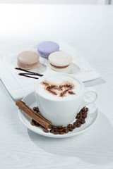 Ice coffee and coffee and nuts near desserts and macaroons in white background