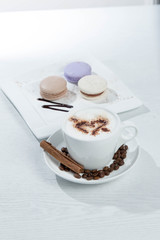 Ice coffee and coffee and nuts near desserts and macaroons in white background