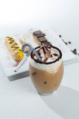 Ice coffee and coffee and nuts near desserts and macaroons in white background