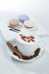 Ice coffee and coffee and nuts near desserts and macaroons in white background