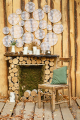 Cozy corner in the garden by the fireplace. Wooden place for rest in the autumn